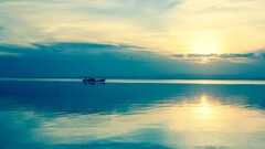 beach water sky sunlight nature Sea horizon boat calm blue