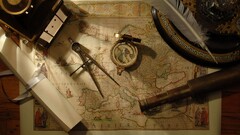 compass Map Tools feathers Scrolls telescope wooden surface