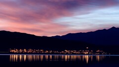 cityscape City Lights reflection calm waters Mountains evening