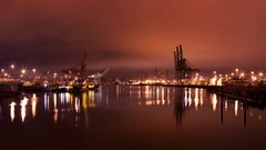cityscape shipyard sky lights cranes (machine) orange background