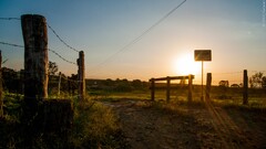 sunset sunlight sun rays signs fence landscape